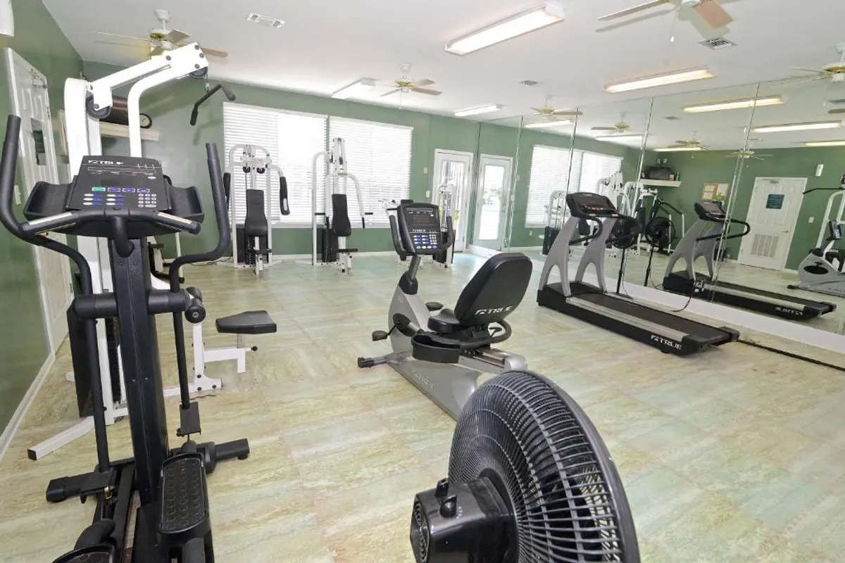 A bright, modern fitness center filled with exercise equipment, mirrors, and open space. The area is designed for both individual workouts and group exercise sessions, reflecting a commitment to resident wellness.